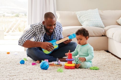 Man and child playing with toys in living room